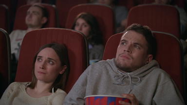 年轻<strong>的</strong>夫妇看恐怖电影电影剧院<strong>的</strong>家伙撒上爆米花